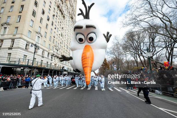 Balloon handlers fight the strong wind gusts and struggle to keep Walt Disney Animation Studios Olaf from Disney's Frozen Balloon and his nose from...