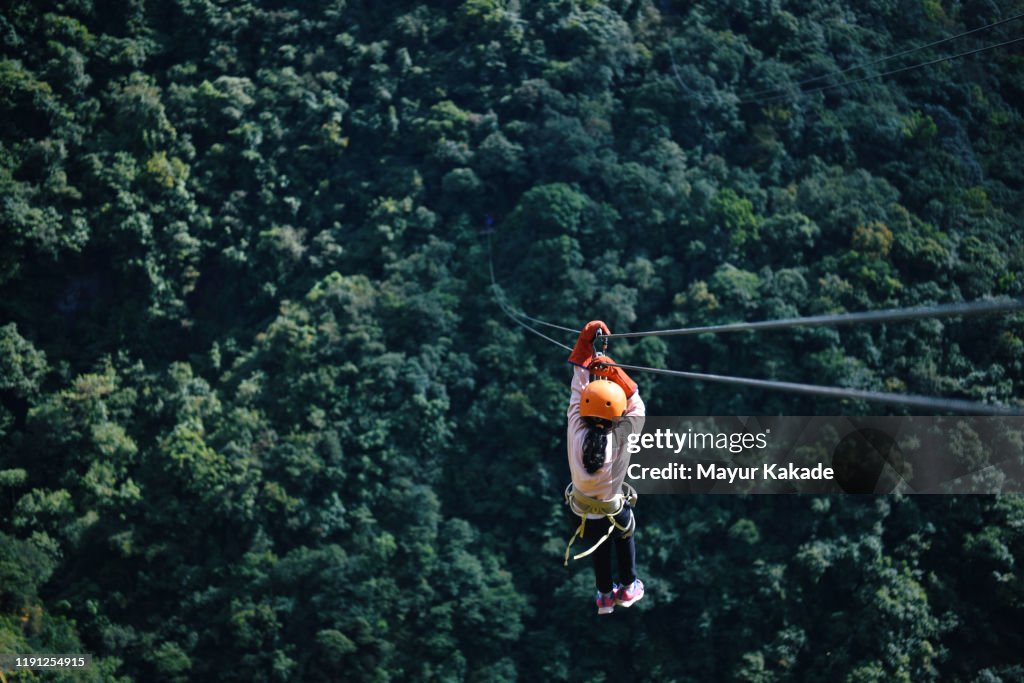Girl Zip lining in the mountains
