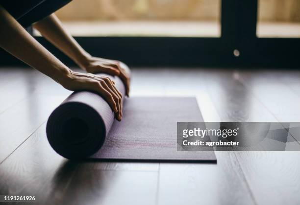 young woman doing yoga twist mat healthy lifestyle - rolled up yoga mat stock pictures, royalty-free photos & images
