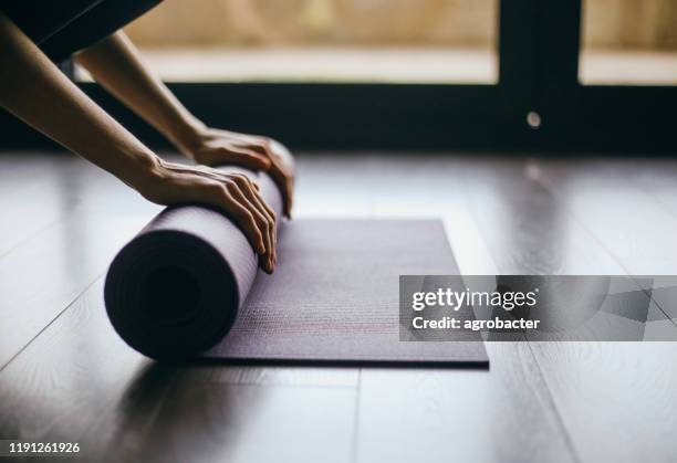 young woman doing yoga twist mat healthy lifestyle - exercise mat stock pictures, royalty-free photos & images