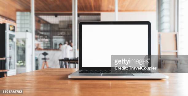 laptop computer blank white screen on table in cafe background. laptop with blank screen on table of coffee shop blur background. - schreibtisch stock-fotos und bilder