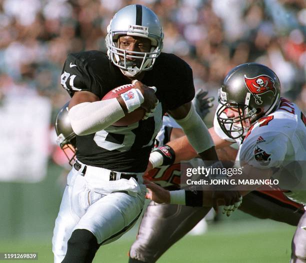 Oakland Raiders wide receiver Tim Brown eludes a tackle from Tampa Bay Buccaneers safety John Lynch to score the Raiders first touchdown on a pass...