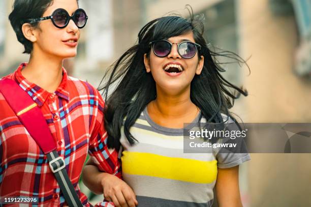 happy, female, best friends walk together in a city. - indian woman short hair stock pictures, royalty-free photos & images