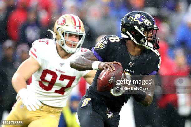 Quarterback Lamar Jackson of the Baltimore Ravens scrambles in front of Nick Bosa of the San Francisco 49ers in the first half at M&T Bank Stadium on...