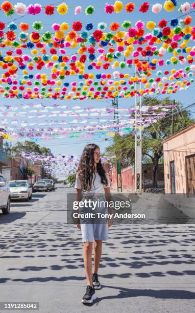 teenage girl walking on street decorated for festival - dorffest stock-fotos und bilder