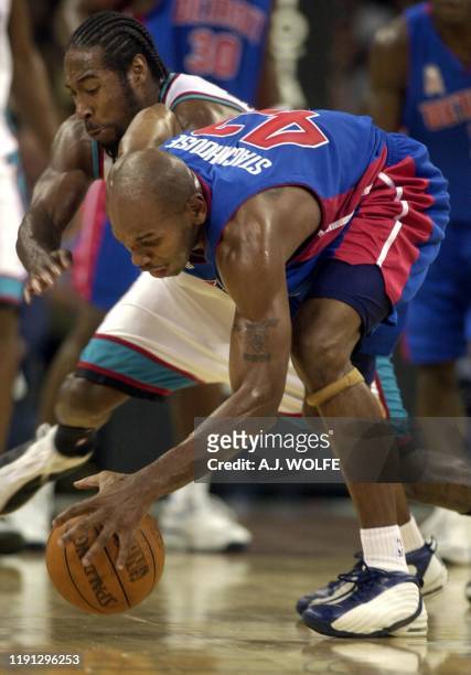 Detroit Piston's Jerry Stackhouse and Memphis Grizzlies' Michael Dickerson go for a loose ball during the first period of their NBA season opener 01...