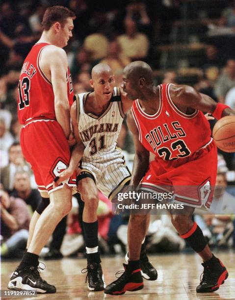 Reggie Miller of the Indiana Pacers runs into a pick set by Luc Longley of the Chicago Bulls for teammate Michael Jordan 29 May during the first half...