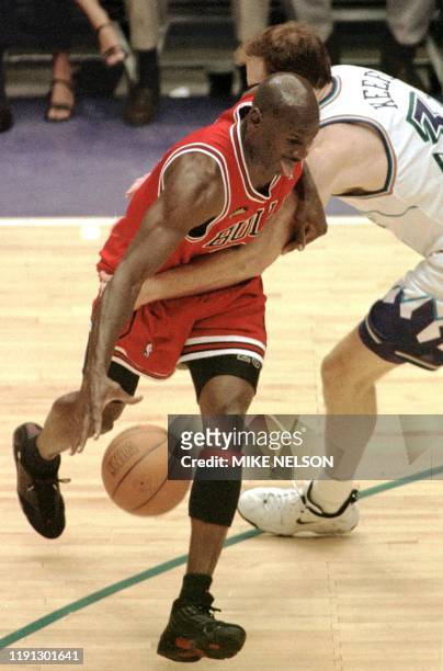 Michael Jordan of the Chicago Bulls is fouled by Adam Keefe of the Utah Jazz 14 June during game six of the NBA Finals at the Delta Center in Salt...