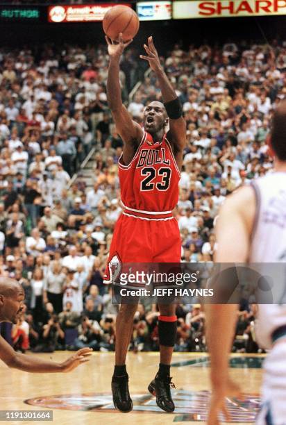 With 5.2 seconds left in the game Michael Jordan of the Chicago Bulls aims and shoots the game-winning jump shot as Bryon Russell of the Utah Jazz...