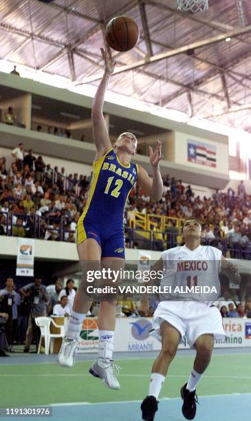 Andrea Silvia of the Brazilian basketball team, shoots with the ball while mexican player Elizabeth Valenzuela is behind her during the America Cup...