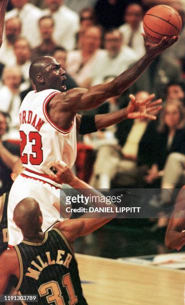 Michael Jordan of the Chicago Bulls drives to the basket past Reggie Miller of the Indiana Pacers 19 May during the first half of game two of their...