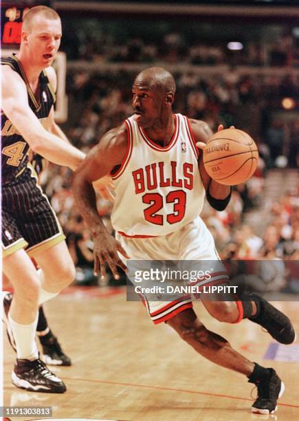 Michael Jordan of the Chicago Bulls drives past Rik Smits of the Indiana Pacers 19 May during the second half of game two of their NBA Eastern...