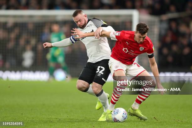 Wayne Rooney of Derby County and Aapo Halme of Barnsley during the Sky Bet Championship match between Derby County and Barnsley at Pride Park Stadium...