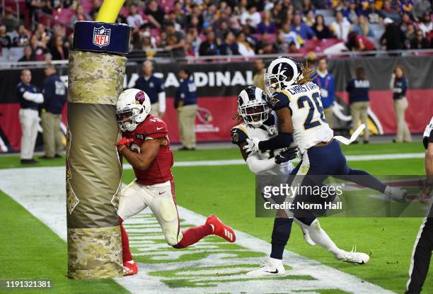 Christian Kirk of the Arizona Cardinals runs into the goal post while attempting to make a catch as Marqui Christian and Nickell Robey-Coleman of the...