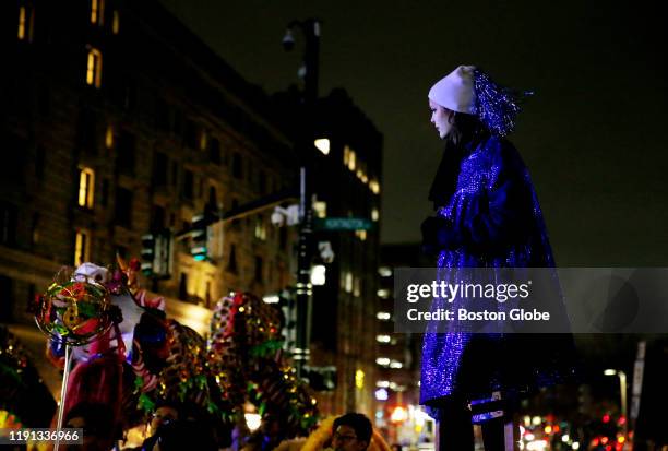 Stilt walker for the Open Air Circus, right, watches as members of the Greater Boston Chinese Cultural Association carry a dragon into Copley Square...