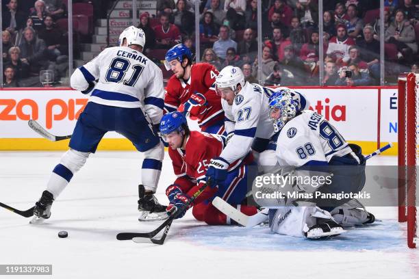 Ryan Poehling of the Montreal Canadiens and Ryan McDonagh of the Tampa Bay Lightning battle for the puck near goaltender Andrei Vasilevskiy during...