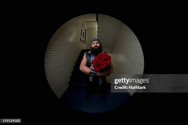 a man with roses viewed through a peephole - peephole stock-fotos und bilder