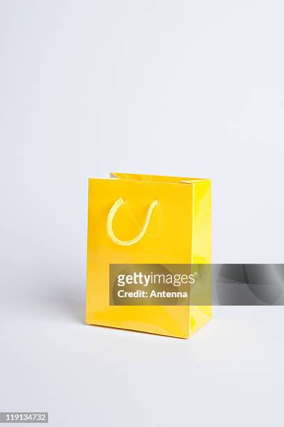 yellow shopping bag - cadeautas stockfoto's en -beelden