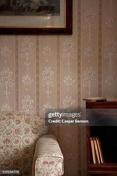 detail of a chair and a bookshelf in an ornate living room - ornate house furniture stock-fotos und bilder