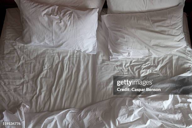 detail of an unmade double bed - white pillow stock pictures, royalty-free photos & images