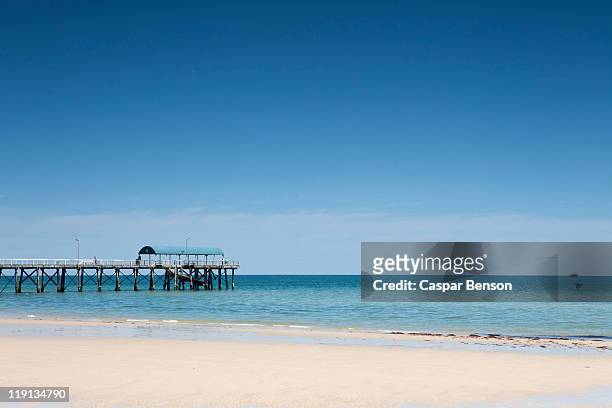 view of a pier from a sandy beach - south australia beach stock pictures, royalty-free photos & images