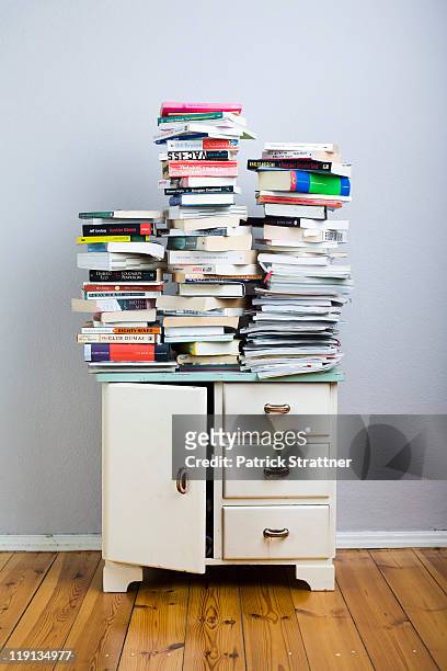 stacks of books on a cabinet - livre broché photos et images de collection