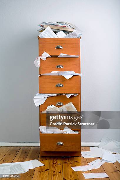 a cabinet stuffed with overflowing papers - archivieren stock-fotos und bilder