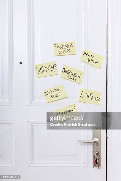 adhesive notes on a front door with various reminders in german - 徹底 ストックフォトと画像