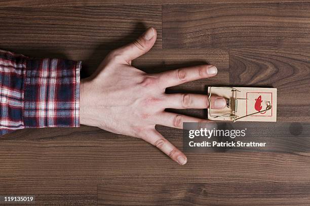 a man's finger trapped in a mousetrap, close-up of hand - mousetrap stock pictures, royalty-free photos & images