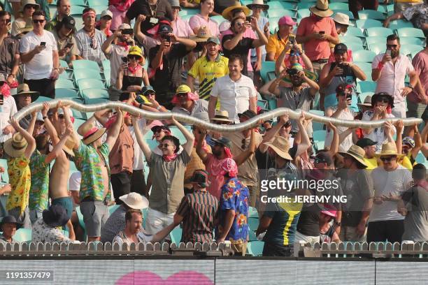 Spectators create a "beer snake" with empty cups during the first day of the third cricket Test match between Australia and New Zealand at the Sydney...