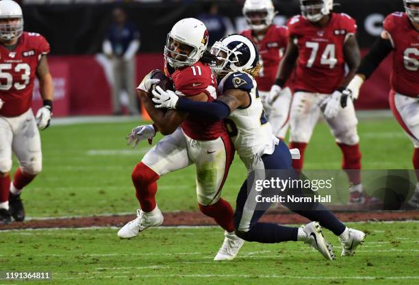 Larry Fitzgerald of the Arizona Cardinals runs with the ball while attempting to break a tackle by Marqui Christian of the Los Angeles Rams at State...