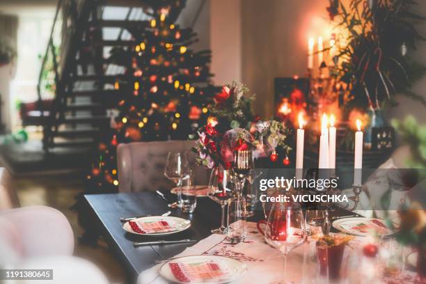 christmas dinner table at festive cozy room background with christmas tree - home party foto e immagini stock