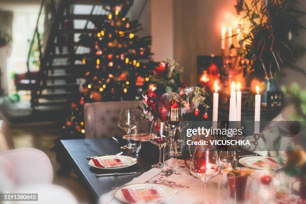 christmas dinner table at festive cozy room background with christmas tree - christmas food stockfoto's en -beelden