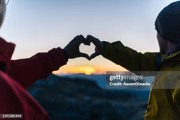 hikers relaxes above mountain valley at sunrise - success makers summit stock pictures, royalty-free photos & images