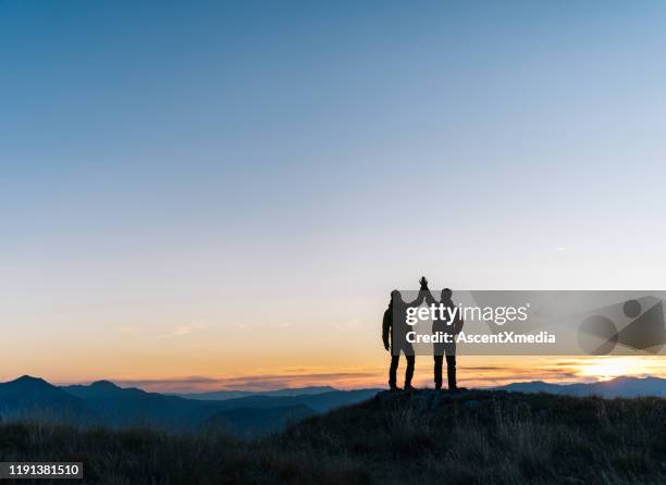 wandelliefhebbers ontspant boven de bergvallei bij zonsopgang - the summit stockfoto's en -beelden