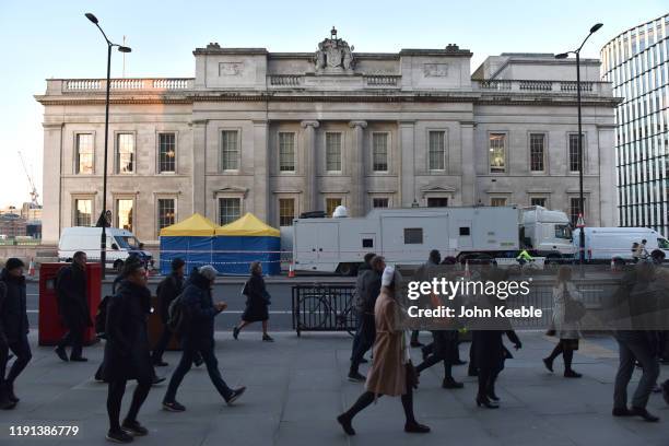 Commuters walk across London Bridge and past Fishmongers' Hall early morning as the bridge is reopened after the recent stabbing attack on December...