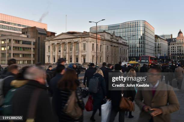 Commuters walk across London Bridge and past Fishmongers' Hall early morning as the bridge is reopened after the recent stabbing attack on December...