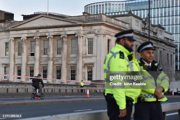 Police officers stand on London Bridge by Fishmongers' Hall early morning as the bridge is reopened after the recent stabbing attack on December 02,...