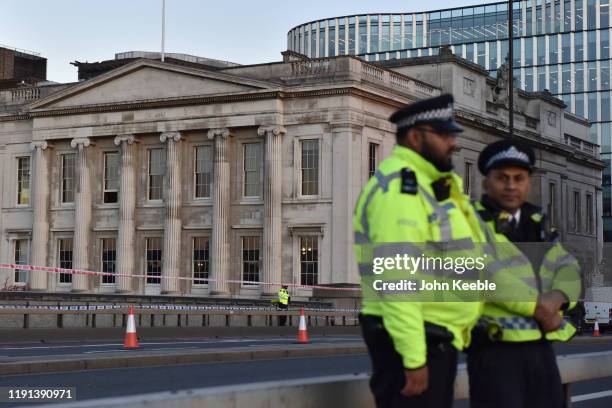 Police officers stand on London Bridge by Fishmongers' Hall early morning as the bridge is reopened after the recent stabbing attack on December 02,...
