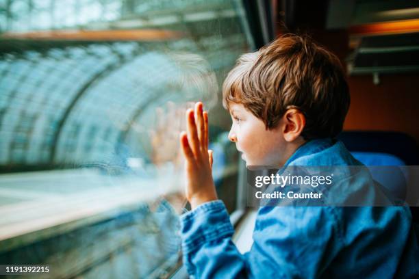 young boy looking out of train window in berlin, germany - vacation train stock pictures, royalty-free photos & images