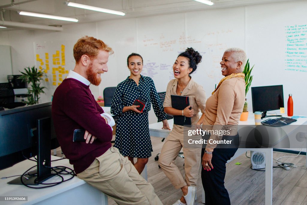Multi-ethnic group of coworkers laughing together at the office