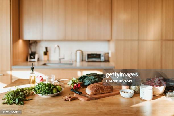 rohkost und zutaten auf der kücheninsel zu hause - kitchen bench wood stock-fotos und bilder