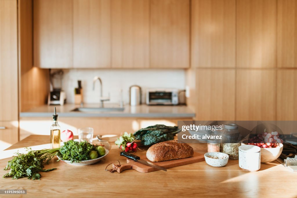 Raw food and ingredients on kitchen island at home