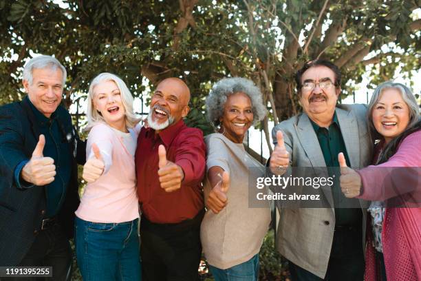 cheerful retired senior friends showing thumbs up - ages 65 70 stock pictures, royalty-free photos & images