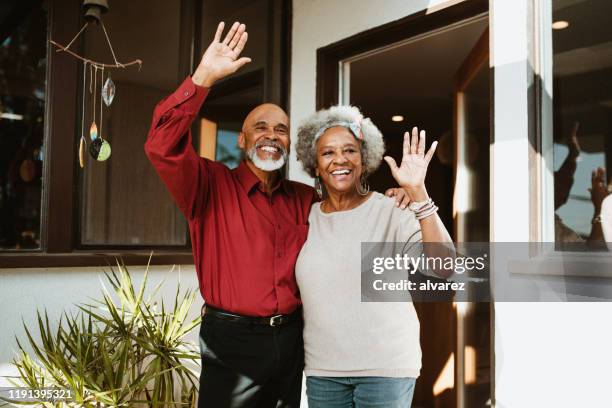 smiling retired man standing with arm around wife - welcome to los angeles stock pictures, royalty-free photos & images