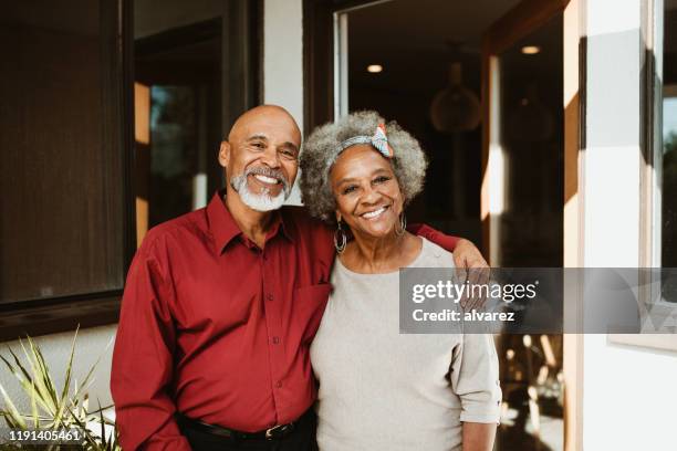 homem aposentado de sorriso que está com braço em torno da esposa - african american couple - fotografias e filmes do acervo