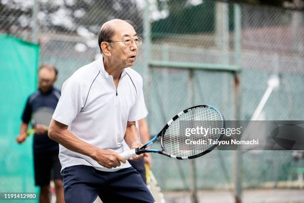 senior man concentrating on tennis - japanese tennis stock pictures, royalty-free photos & images