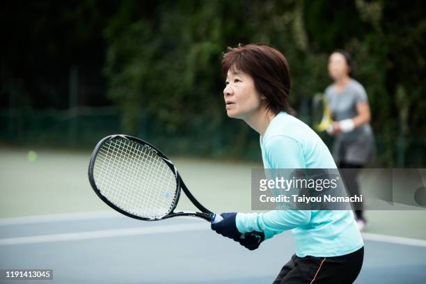 japanese woman enjoying tennis - japanese tennis stock-fotos und bilder