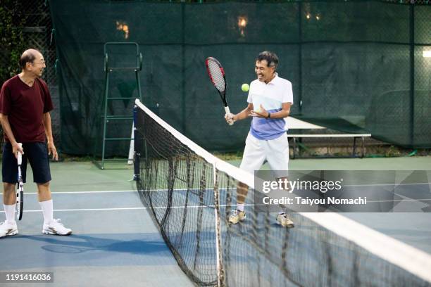 senior men enjoying tennis together - japanese tennis stock pictures, royalty-free photos & images