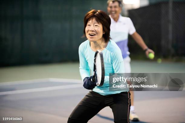 tennis team enjoying a doubles match - japanese tennis stock-fotos und bilder